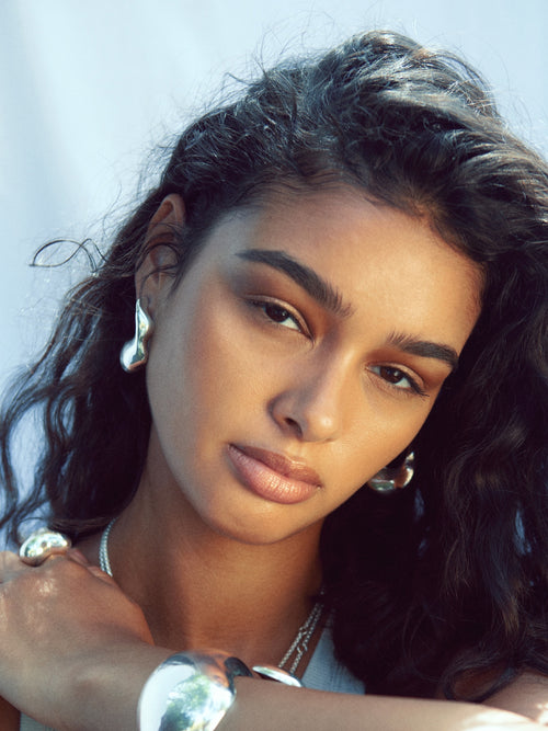 detail shot of MOUNSER Large Rose Hoop Earrings in Sterling Silver, handcrafted sculptural free form earrings with a mirror polish 