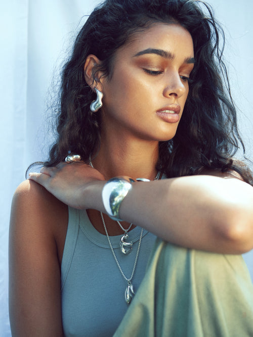 MOUNSER Large Rose Hoop Earrings in Sterling Silver, handcrafted sculptural free form earrings with a mirror polish on model