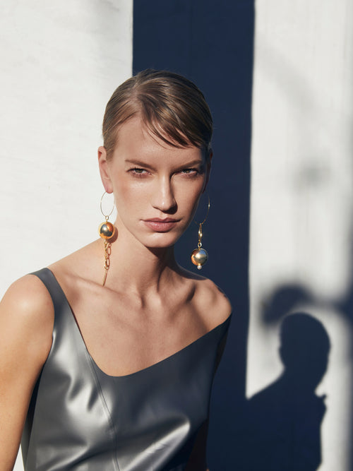 model shot of MOUNSER Solar Hoops in Gold sculptural kinetic statement hoop earring with ball charms 