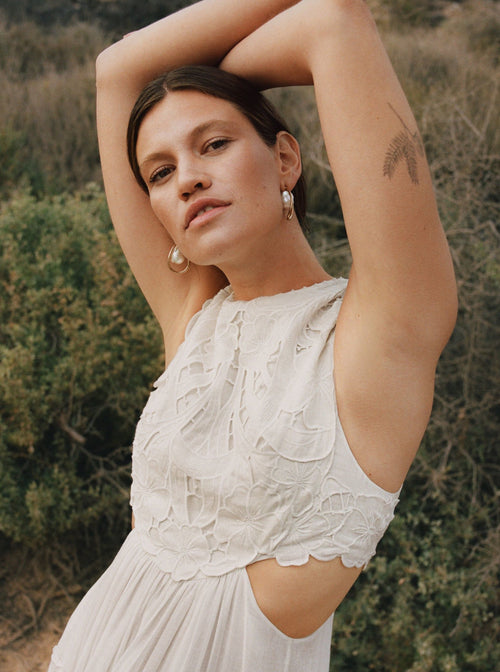outdoor shot of MOUNSER Waxing Hoop Earrings in Gold architectural hoop earring with pearl charm.