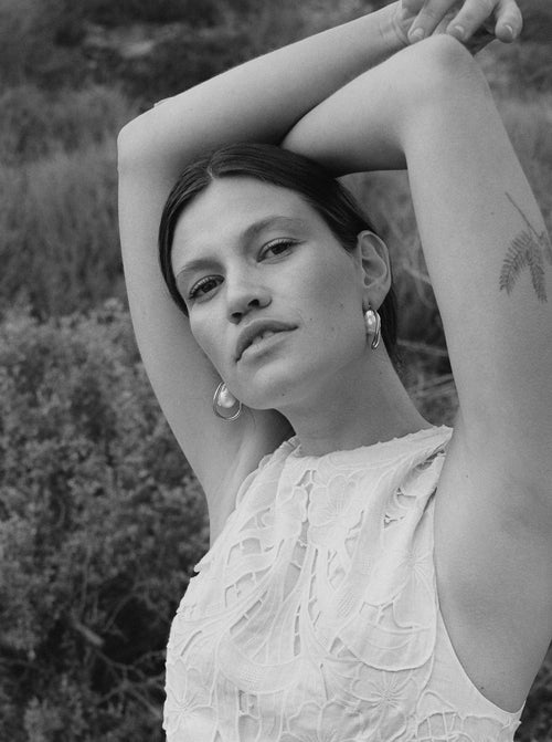 outdoor shot of MOUNSER Waxing Hoop Earrings in Silver architectural hoop earring with pearl charm.