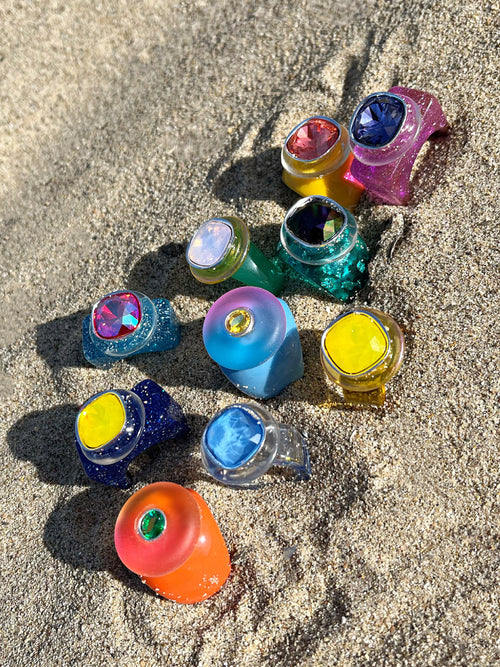 A still life featuring MOUNSER Ring Pop in Pool and a collection of colorful sculptural cocktail rings