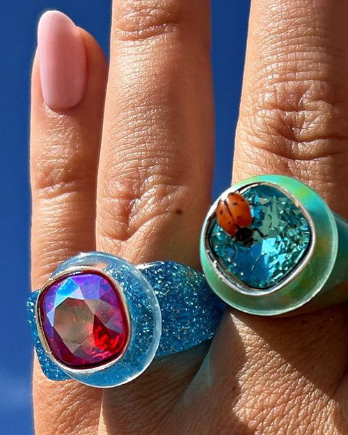 Close-up of MOUNSER Ring Pop in Pool with acrylic resin band and Austrian crystal stone